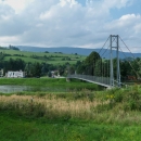 Most přes řeku Oravu v Dolném Kubíně, v dáli vyčuhuje hřeben Oravské Magury s nejvyšším vrcholkem Minčol