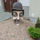Socha poslední - hlava Charlie Chaplina trčí ze země před vinotékou ve Veselské uličce v sousedním Žďáru nad Sázavou
