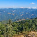 Výhled přes Ľubochnianskou dolinu na sousední hřeben, úplně vzadu v dálce Nízké Tatry