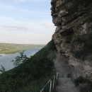 Cesta ke skalnímu klášteru Tipova. Klášter je vytesán ve svahu nad řekou Dněstr, domky naproti patří k Podněsterské republice.